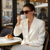 A high-value woman at a cafe sipping coffee